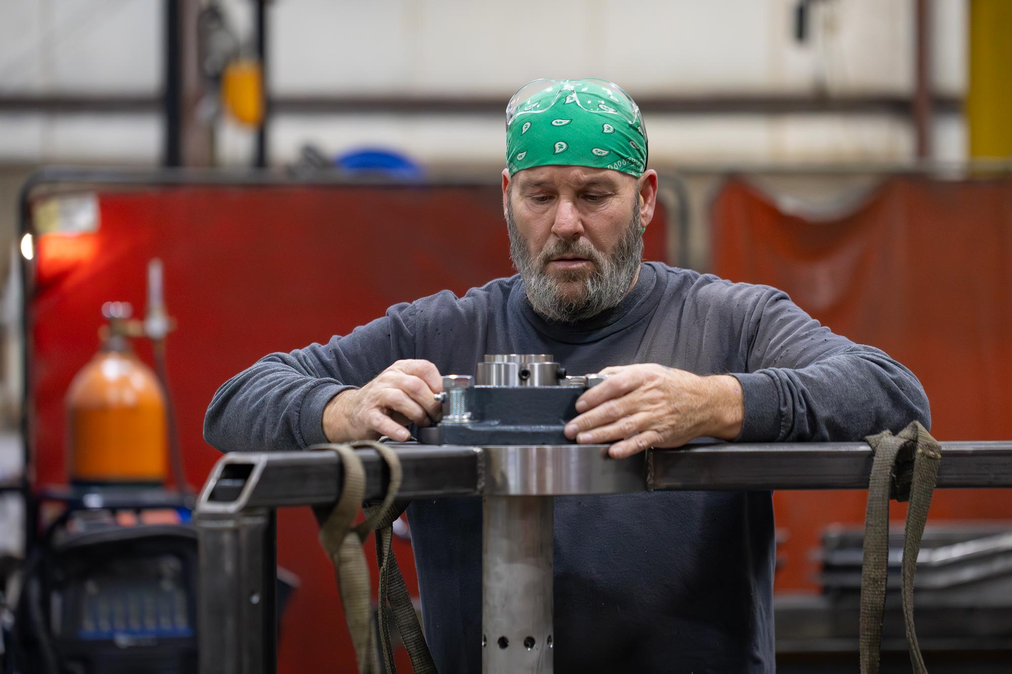 Machinist working on a metal part in a factory