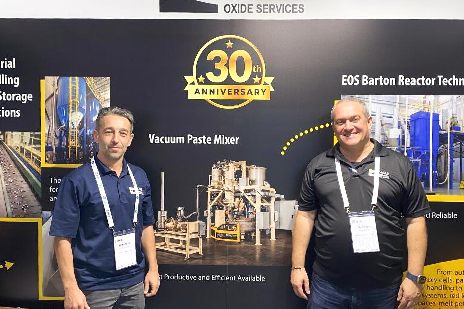 two people standing in front of the EAGLE booth at ELBC