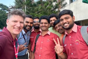 Eric Holtan with group of men taking a selfie. global customers