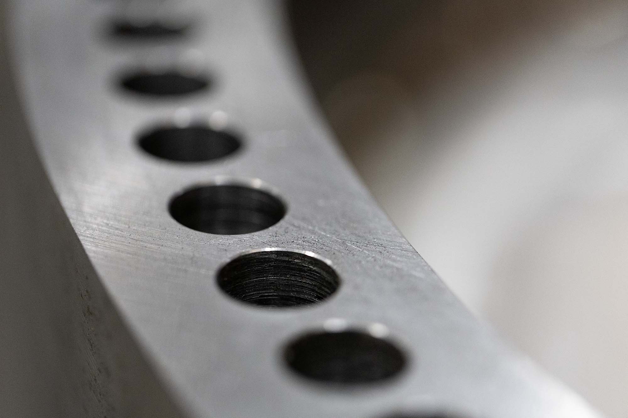 Detail of a curved metal part with drilled holes