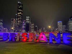 Lighted "Brisbane" letters with night time cityscape in the background