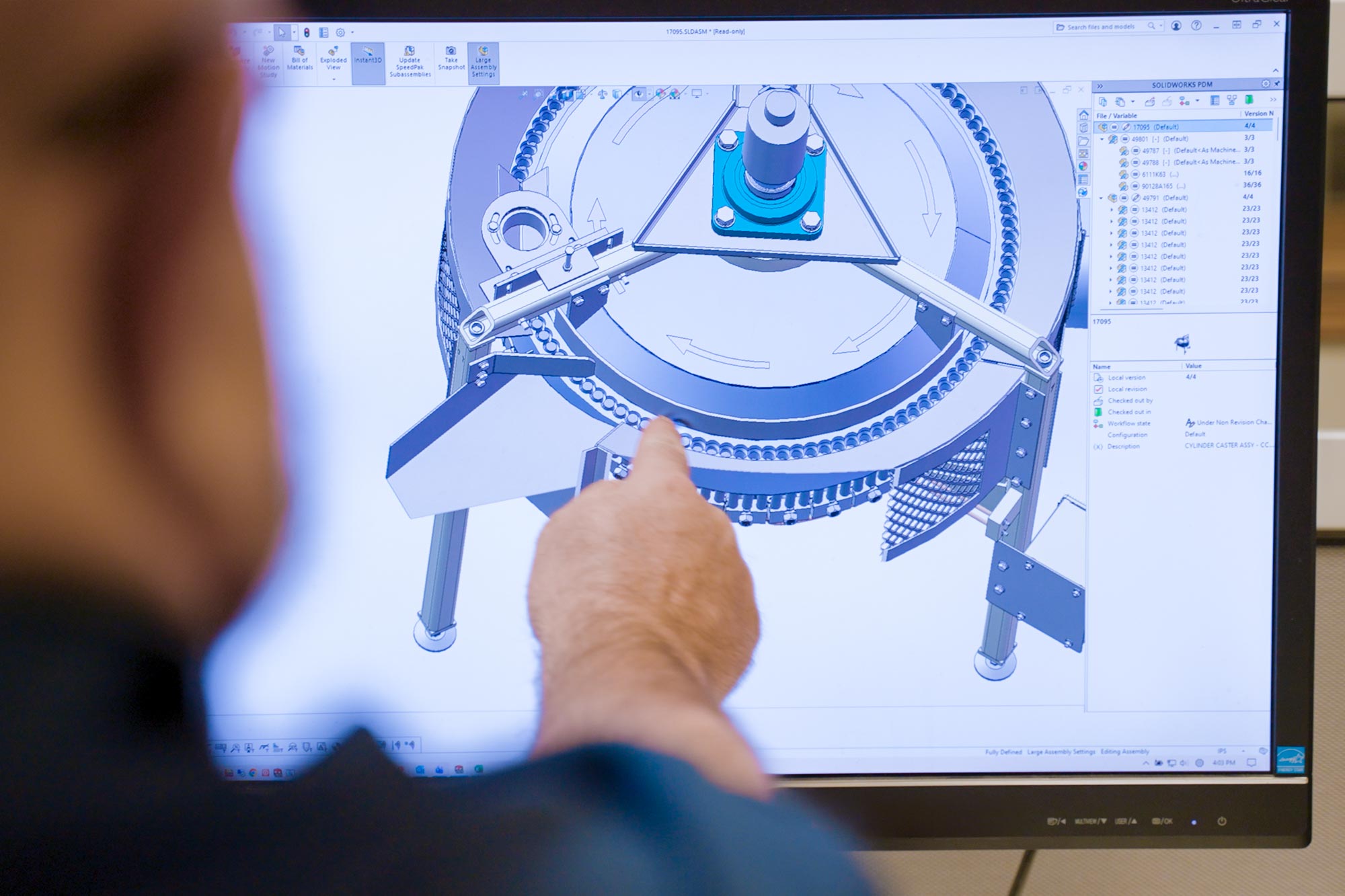 Caster schematics on a computer screen with engineer pointing at a detail
